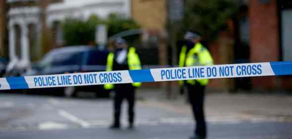 Police officers stand behind a cordon