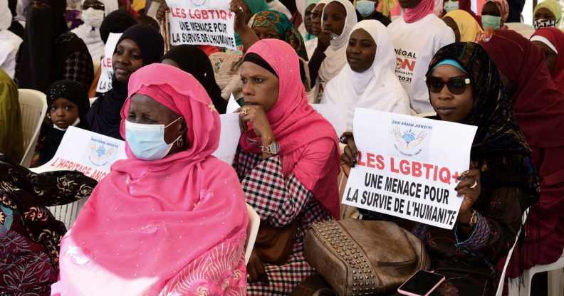A woman in Senegal holds a sign reading 'LGBT is a threat for humanity' during a protest called by religious associations against homosexuality in 2021