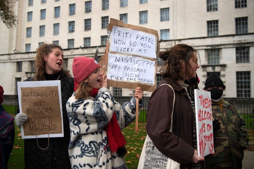 Protesters hold up placards as they demonstrate against the government's Nationality and Borders Bill outside Downing Street