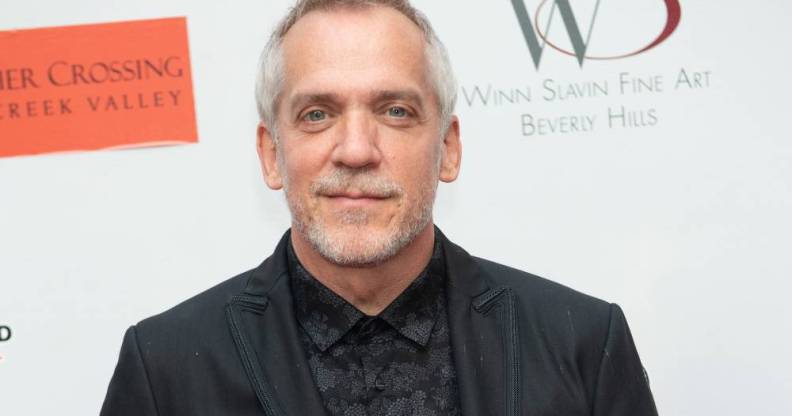 Director Jean-Marc Vallée poses in a black shirt and suit jacket in front of a white background