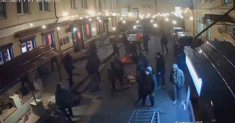 Several people in dark clothes are captured on camera destroying the outside of HvLv, a gay bar in Kyiv, Ukraine