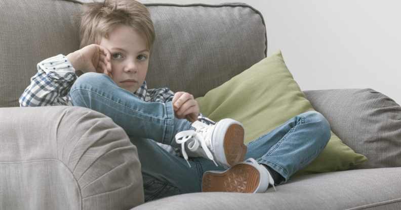 Sad boy sitting on an armchair