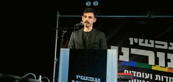 Omri Feinstein speaking at a protest against sexual violence.