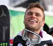 Gus Kenworthy wears ski gear while smiling up