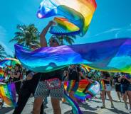 People wave rainbow coloured banners during a Pride parade at the Miami Beach Pride Festival