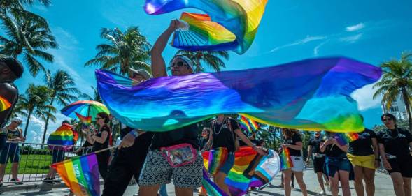 People wave rainbow coloured banners during a Pride parade at the Miami Beach Pride Festival