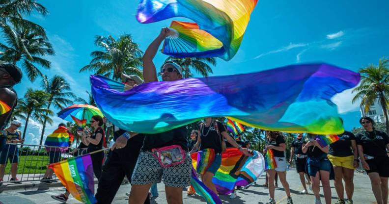 People wave rainbow coloured banners during a Pride parade at the Miami Beach Pride Festival