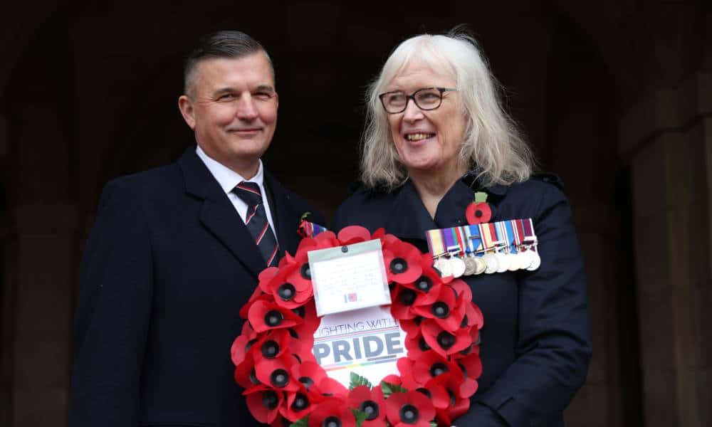 LGBT+ veterans and joint CEOs of charity Fighting With Pride Craig Jones and Caroline Paige hold a wreath made of red poppies