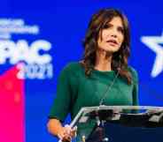 South Dakota governor Kristi Noem speaks at a podium while dressed in a green outfit