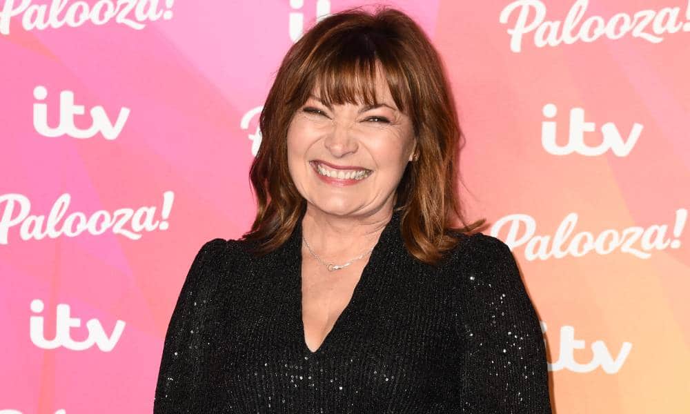 Lorraine Kelly smiles at the camera while wearing a black sparkly outfit