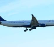 A Delta branded airplane flies in a blue sky