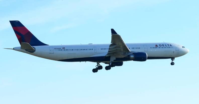 A Delta branded airplane flies in a blue sky