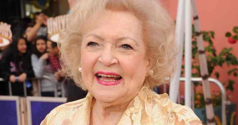 Betty White smiles at the camera while wearing a light yellow patterned top