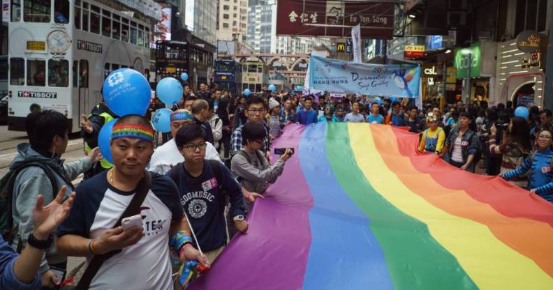 Participants of Hong Kong's annual pride parade march with a giant rainbow flag