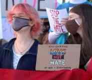 People hold a sign that reads 'Encourage love not hate at SDA + everywhere'