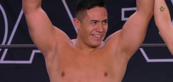 Jake Atlas holds up his arms in triumph after winning his debut match with All Elite Wrestling