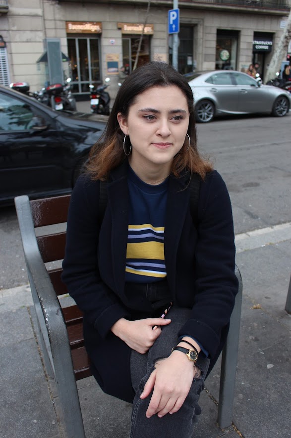 Daniella Leon looks away from the camera while wearing a black jacket and striped top