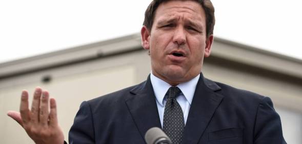 Ron DeSantis wears a suit and tie during a press conference