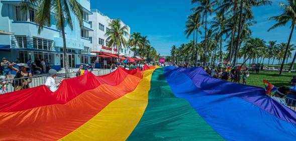 A rainbow flag flies over Ocean Drive as people participate in a Pride parade at a Pride festival in Florida