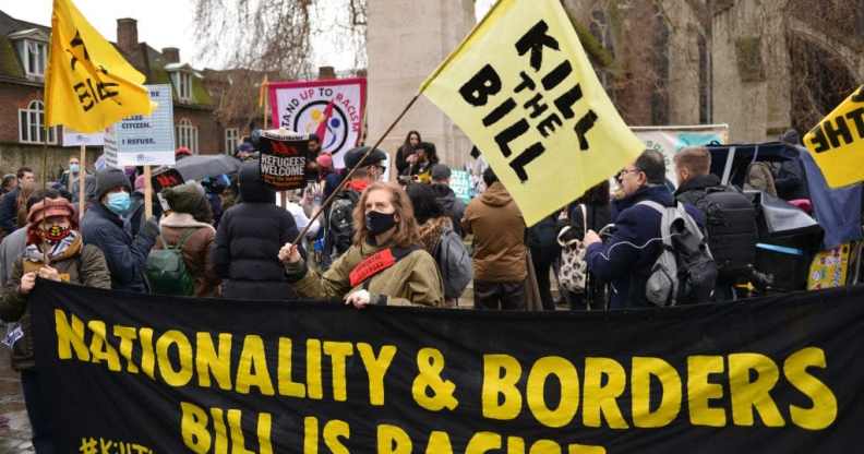 Demonstrators hold a banner and flags with slogans during the rally.