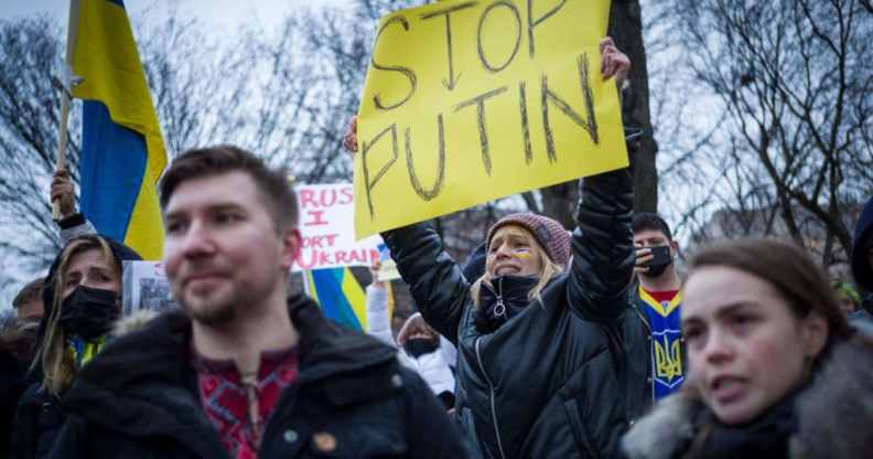 Activists hold placards and flags as they gather in Lafayette Square to protest Russia's invasion of Ukraine in Washington, DC.