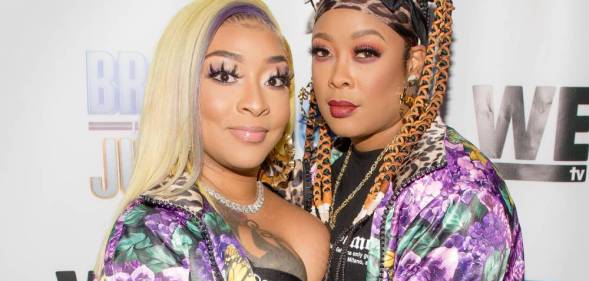 Jesseca Dupart and Da Brat stare at the camera while wearing pink and purple patterned tops