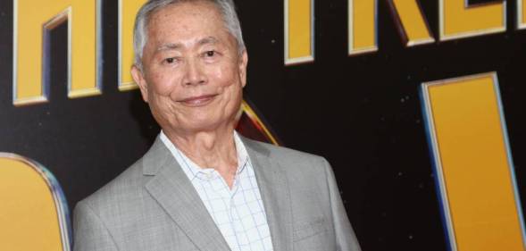 George Takei, an Japanese-American actor, looks at the camera while wearing a white shirt and grey jacket