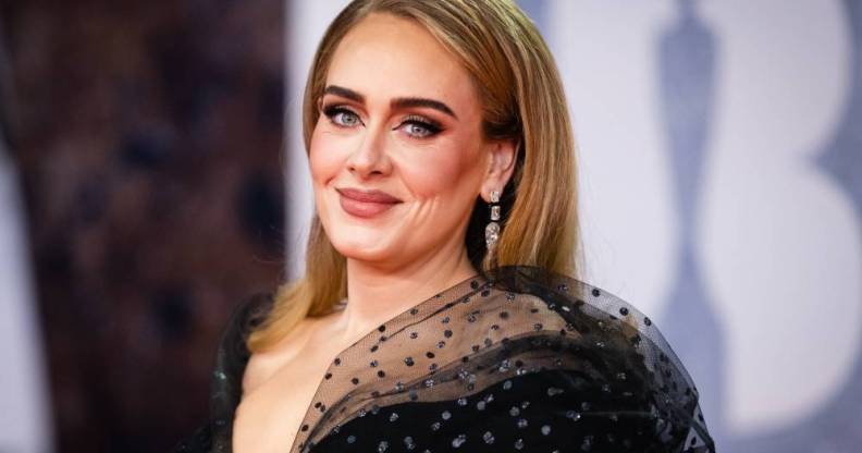 Adele, a white woman, wears a black dress during an appearance at the 2022 BRIT Awards