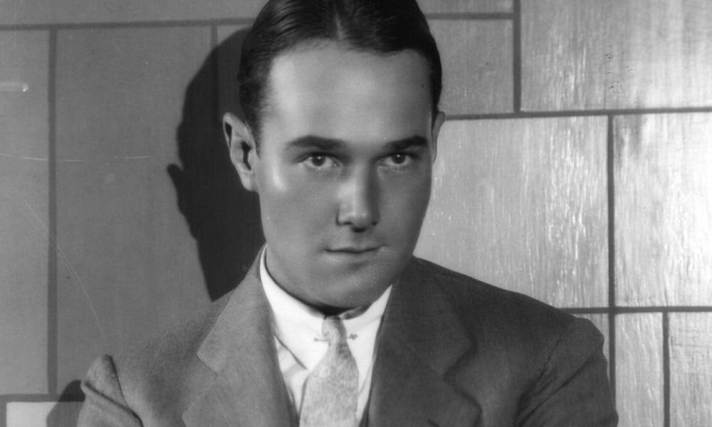 William Haines, a white man, wears a suit and a tie in a black and white photo