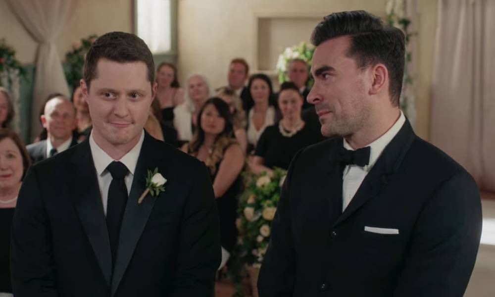 Two men stand in black and white wedding attire