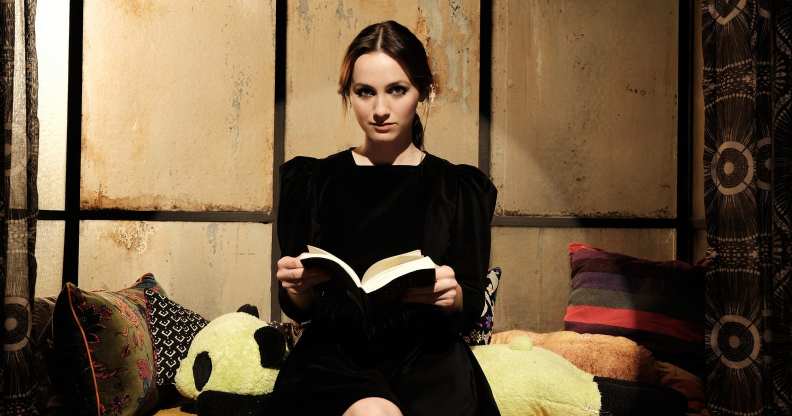 Lexi sat on a play set, holding a book