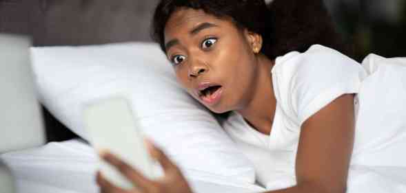 Shocked young woman laying in bed