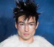 Actor Ezra Miller is seen wearing a white fluffy outfit with silver makeup and fluffy dark hair with white tips