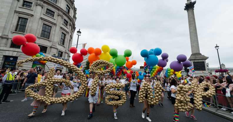 Revellers carry a Disney logo during the Pride in London parade on 06 July, 2019 in London, England