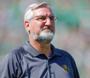 Eric Holcomb, the governor of Indiana, wears a blue polo shirt with a gold logo over his left chest