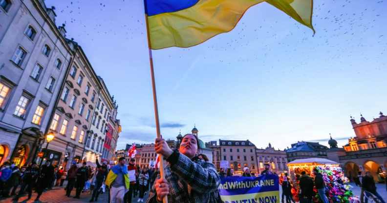 A protester waves a Ukrainian flag during a protest in Krakow, Poland.