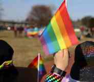 Student holds LGBT+ Pride flag during protest in support of the LGBT+ community