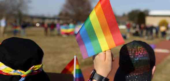 Student holds LGBT+ Pride flag during protest in support of the LGBT+ community