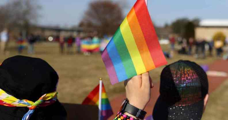 Student holds LGBT+ Pride flag during protest in support of the LGBT+ community