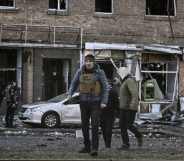 Kyiv's mayor Vitali Klitschko (C) walks in front of a destroyed apartment building, in Kyiv on March 14, 2022.