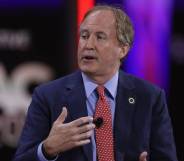 Texas attorney general Ken Paxton is seen wearing a light blue shirt, red tie and darker blue suit jacket