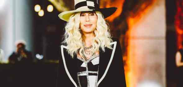 Cher, pop music legend, attends the Academy Museum of Motion Pictures Opening gala wearing a black and white top hat with a black and white sparkly top