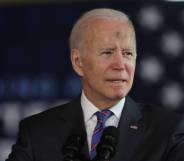 Joe Biden, the president of the United States, stands at a podium with an American flag in the background