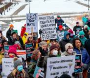 Crowd of people hold up signs in support of trans youth across the USA