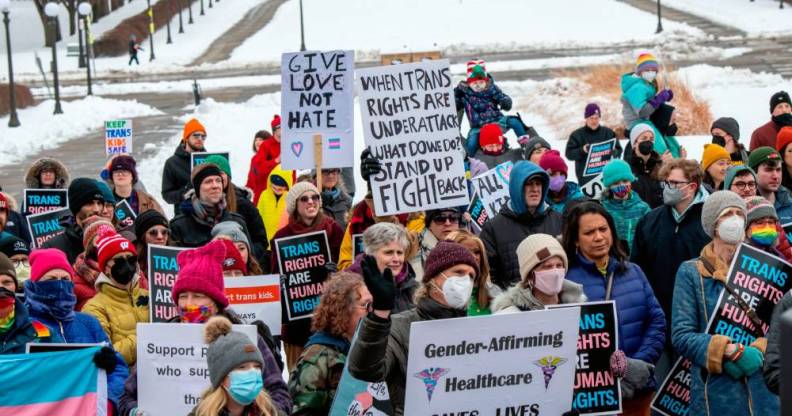 Crowd of people hold up signs in support of trans youth across the USA