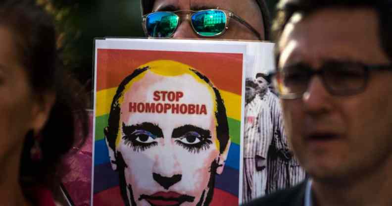 A man showing a picture of Vladimir Putin during a protest supporting LGBT+ people in Chechnya