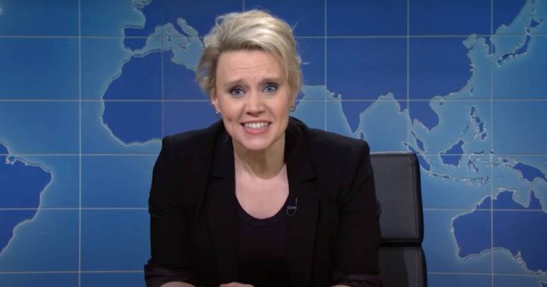 Kate McKinnon, a cast member of Saturday Night Live, wears a black outfit as she appears in front of a fake news desk set up on the show's Weekend Update segment