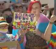 A person holds a sign up in support of the trans community that reads "HRT saves lives" amid protests in Texas