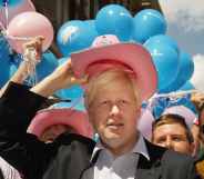 Boris Johnson wearing a pink stetson in front of blue, pink and white balloons