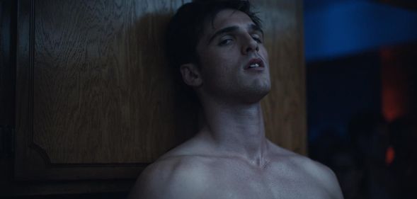 Jacob Elordi as Nate in Euphoria, standing topless against a wall